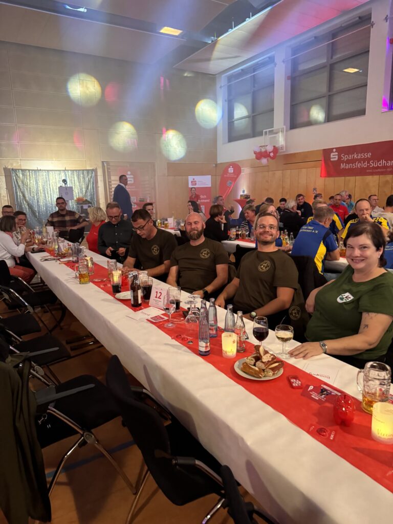 Mitglieder des Heimatvereins Stolberg am Vereinstisch in der festlich beleuchteten Mammuthalle
