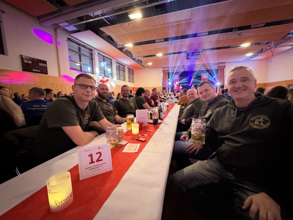 Mitglieder des Heimatvereins Stolberg sitzen gemeinsam an einer langen Festtafel in der Mammuthalle